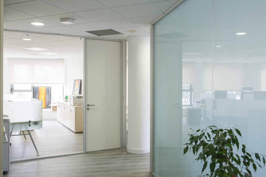 Mampara de oficina con un vidrio a testa con pueta ciega