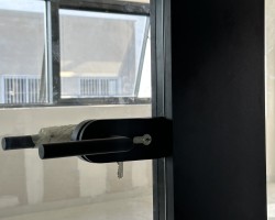 Manivela con cerradura en puerta de vidrio seguridad