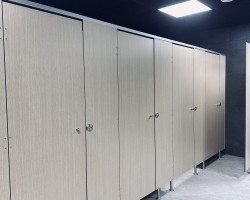 Cabinas sanitarias cornisa aluminio plata con melamina color haya en gimnasio Areafit en Murcia