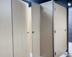 Cabinas sanitarias en melamina con cornisa en aluminio plata y herrajes acero inoxidable